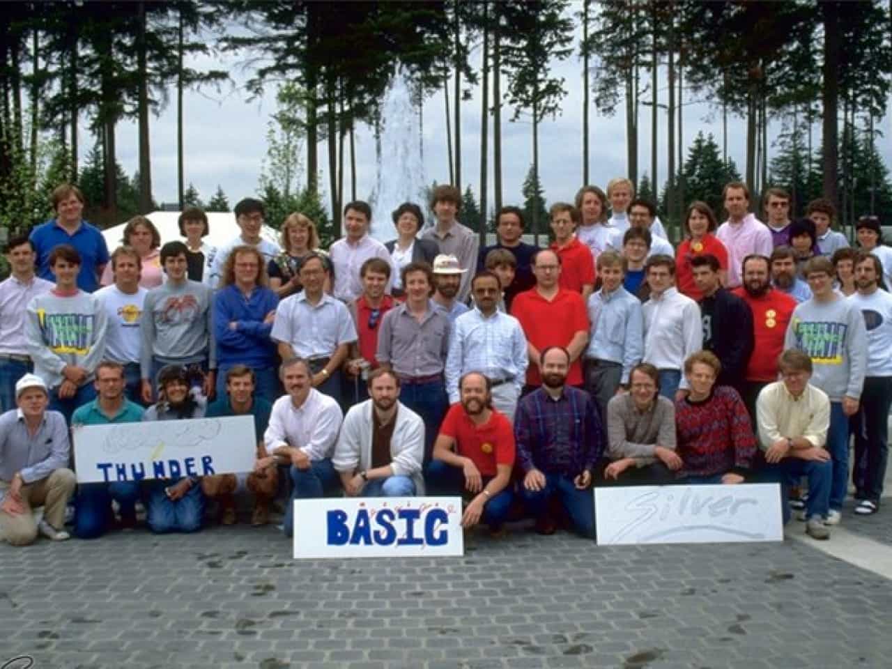 An photograph of the Microsoft Business Language Group members at a team event. Some people are holding signs that read 'Thunder', 'BASIC', and 'Silver'.